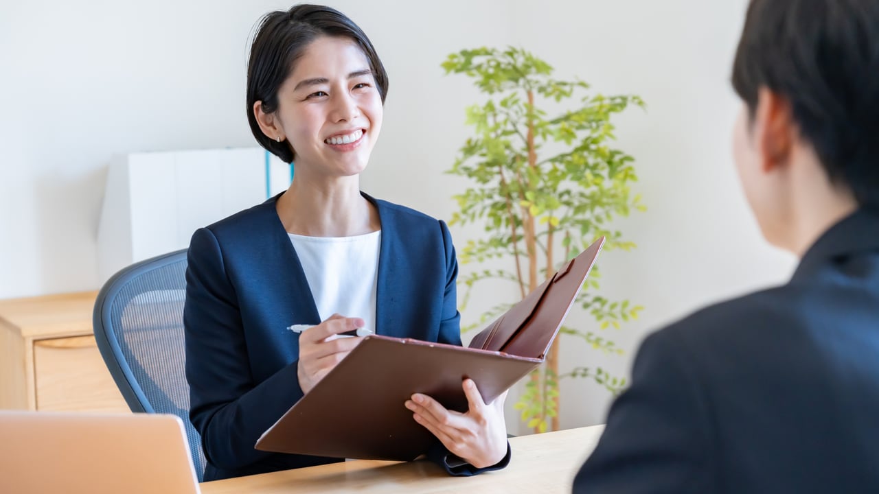従業員との面談で、書類を手に説明する担当者のイメージ