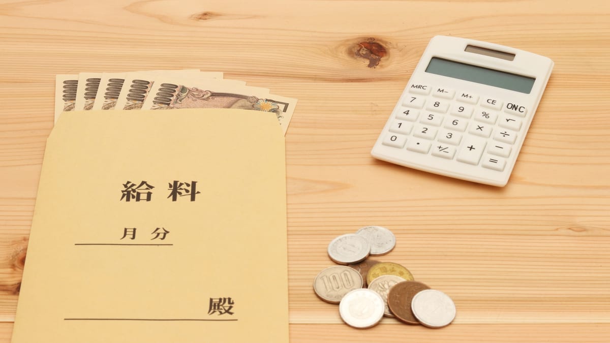 給料袋と電卓、硬貨のイメージ