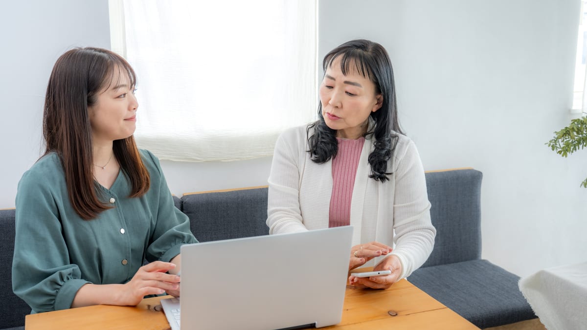 ノートパソコンを見ながら話し合う2人の女性のイメージ
