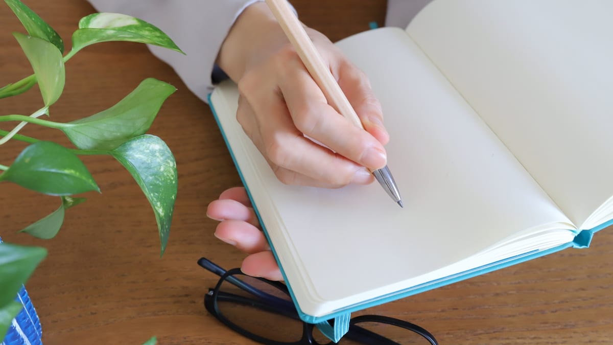 ノートに書き込む手元のイメージ