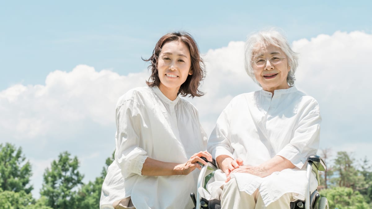 車いすの母に寄り添う娘のイメージ
