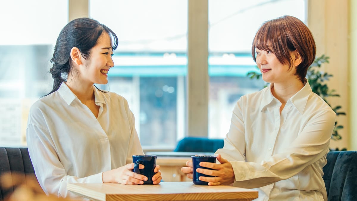 テーブルをはさんで話し合う2人の女性のイメージ