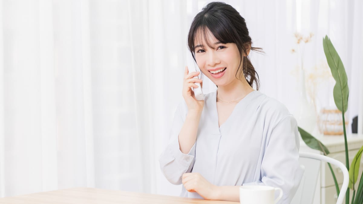 自宅から電話で連絡する女性のイメージ