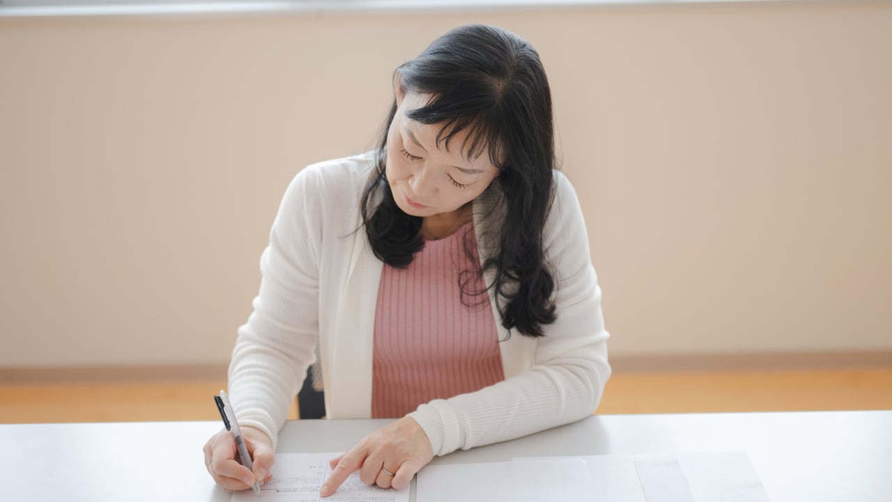 自宅で書類を確かめる女性のイメージ