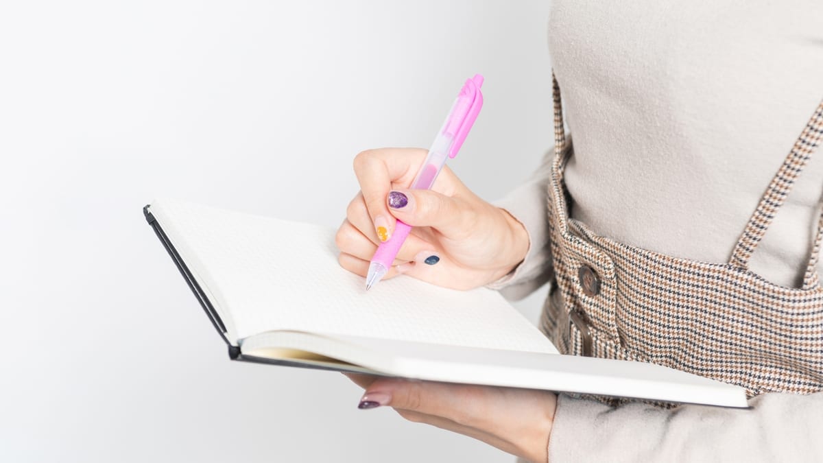 ノートにメモを書き込む手元のイメージ