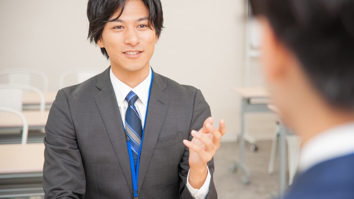 向かい合って話を聞くスーツ姿の男性のイメージ