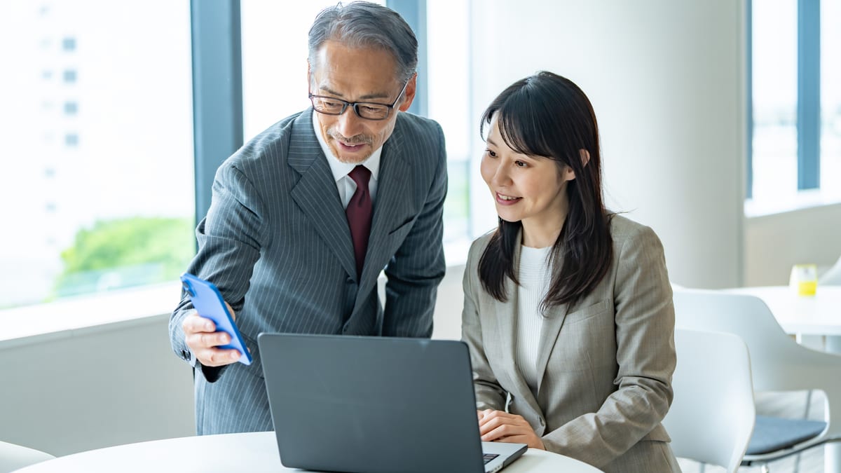 ノートパソコンを前に話し合う2人のイメージ