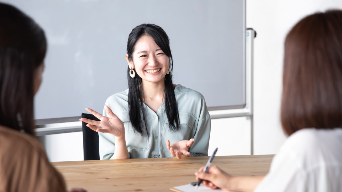 会議室で、向かいの相手に話す女性のイメージ